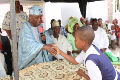 Alhaji Alli Olanusi presenting scholarship to one of the 37 students
