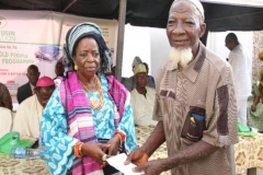 Iyaloja of Ondo Kindom presenting an envelope to one of the beneficiaries