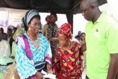 Iyaloja of Ondo Kingdom presenting an envelope to an old woman at the event